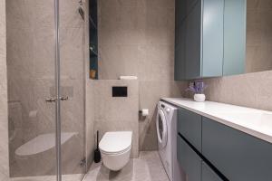 a bathroom with a toilet and a glass shower at cohost I New Bastėja Life Apartments w-Garage Prkg & Self Check-in in Vilnius