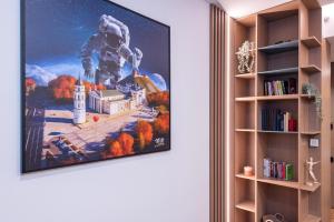 a painting of an astronaut hanging on a wall at cohost I New Bastėja Life Apartments w-Garage Prkg & Self Check-in in Vilnius