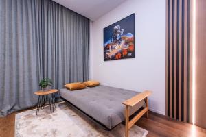 a bedroom with a bed and a table in a room at cohost I New Bastėja Life Apartments w-Garage Prkg & Self Check-in in Vilnius