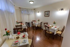 a dining room with tables and chairs with white tablecloths at Vila Paris Boutique Hotel in Bucharest