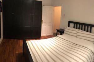 a bedroom with a large bed with white sheets at Home on Hamill Street in Belfast