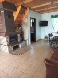 a living room with a brick fireplace and a television at Domek Rokitki in Rokity