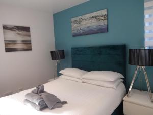 a bedroom with a white bed with two lamps at Dandy Lodge, Bowness-on-Solway in Bowness-on-Solway