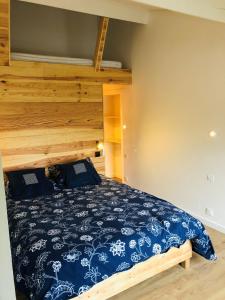 une chambre avec un lit avec un couvre-lit bleu et blanc dans l'établissement Uluwatu - cottage cosy, à Saint-Laurent-de-Médoc