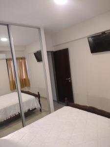 1 dormitorio con espejo, 1 cama y 1 cama sidx sidx sidx sidx en Departamento 2 ambientes céntrico en Tucumán en San Miguel de Tucumán