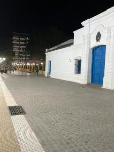 un edificio blanco con puertas azules en una calle en Departamento 2 ambientes céntrico en Tucumán en San Miguel de Tucumán