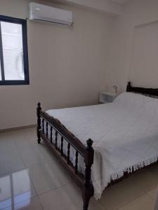 1 dormitorio con 1 cama con edredón blanco y ventana en Departamento 2 ambientes céntrico en Tucumán en San Miguel de Tucumán