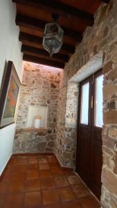 a room with a stone wall and a wooden door at Casa Doña Elena in Bernal