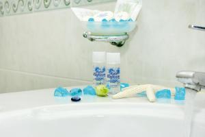 a bathroom sink with a pile of toiletries on it at Hotel Capizzo in Ischia