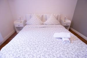 a bedroom with a white bed with towels on it at Spacieux Cœur de Reims in Reims