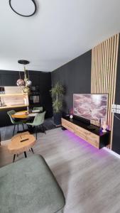 salon z telewizorem z płaskim ekranem i stołem w obiekcie Superbe appartement dans un quartier neuf et calme w Strasburgu