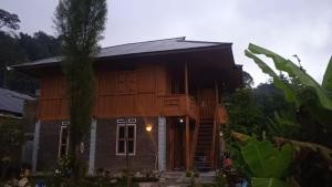 een houten huis met een trap ervoor bij THE SINGKI HOME FAMILY in Rantepao