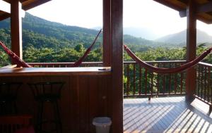 a balcony with a hammock and a view of the mountains at Coral Sea Views in Diwan