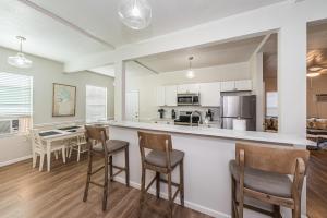 a kitchen and living room with a bar and chairs at Frenchy's Cottage 482 in Clearwater Beach