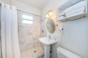 a white bathroom with a sink and a shower at Frenchy's Cottage 482 in Clearwater Beach
