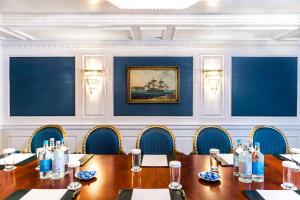 a conference room with a wooden table and chairs at Bentley London in London