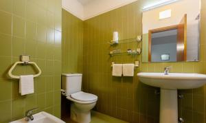 zieloną łazienkę z toaletą i umywalką w obiekcie Hotel Sao Nicolau w mieście Braga
