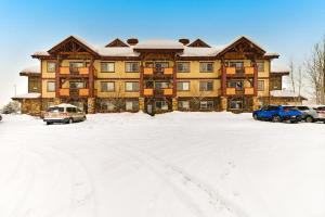 a large building with cars parked in a snow covered parking lot at First Tracks 4202 in Steamboat Springs