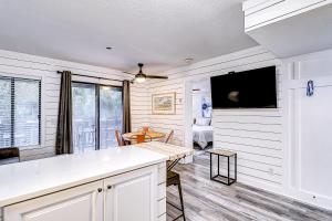 una cucina con tavolo e una TV in camera di Carolina Beach Club, Unit 126 a Hilton Head Island