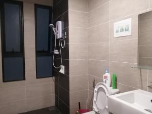 uma casa de banho com um chuveiro, um WC e um lavatório. em Midhills studio aircond WiFi em Genting Highlands