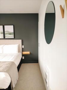 a bedroom with a bed and a mirror on the wall at Boutique Motel in Nelson