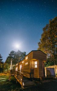 a wooden cabin in a field at night at Umpqua's Last Resort - Wilderness Cabins, RV Park & Glamping in Idleyld Park
