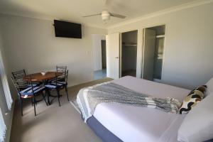 a bedroom with a bed and a table with chairs at BLK Stays Guest House Deluxe Units Morayfield in Morayfield