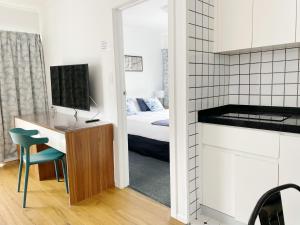 una camera con letto e scrivania con TV di Pupuke Manor Motel ad Auckland