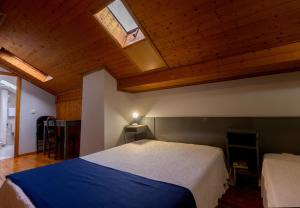 sypialnia z dużym łóżkiem i oknem dachowym w obiekcie Hotel Sao Nicolau w mieście Braga