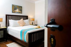 a bedroom with a bed with white sheets and pillows at Boutique by The Museo in Mérida