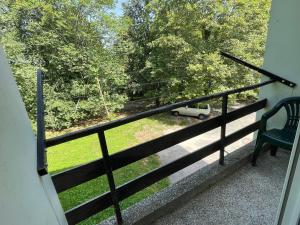 a balcony with a view of a car parked on a field at At the heart of Plitvice Lakes - Self check-in! in Plitvička Jezera