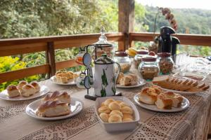 Pousada Evolucao في ماكاكوس: طاولة مليئة بأطباق المعجنات على طاولة