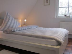 Bett in einem Zimmer mit Fenster in der Unterkunft Ferienwohnung im Stadthaus - zwei Schlafzimmer in Winsen