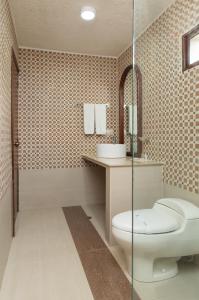 un bagno con wc e doccia in vetro di Hotel Zaracay a Santo Domingo de los Colorados