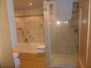 un bagno con doccia, vasca e lavandino di Haus Rottenstein a Neukirchen
