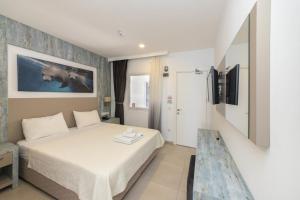 a hotel room with a bed and a tv at Seafront Flat with Excellent Sea View in Bodrum in Bodrum City