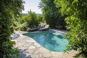 una piscina en un patio trasero con 2 tumbonas en Cozy House with Garden in Bodrum Bitez, en Bitez