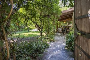 un jardín con mesa, sillas y árboles en Cozy House with Garden in Bodrum Bitez, en Bitez