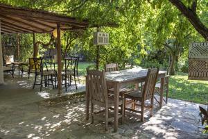 una mesa de madera y sillas bajo un cenador en Cozy House with Garden in Bodrum Bitez en Bitez