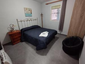 1 dormitorio con 1 cama, 1 silla y 1 ventana en Casa rural miralmonte, en Moratalla