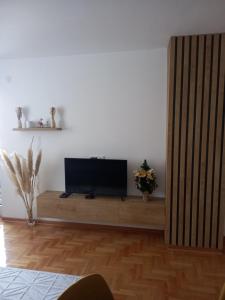 ein Wohnzimmer mit einem Flachbild-TV auf einem hölzernen Entertainment-Center in der Unterkunft Welcome Apartments in Niš
