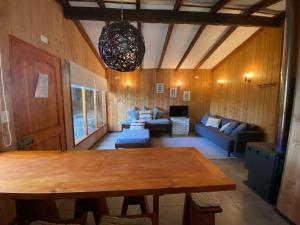 a living room with a table and a couch at Cabañas Koyam Ruka in Licán Ray