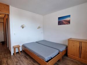 ラ・プラーニュにあるAppartement La Plagne, 3 pièces, 7 personnes - FR-1-351-61のベッドルーム1室(ベッド1台付)、木製キャビネットが備わります。