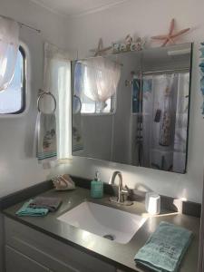 a bathroom with a sink and a mirror at Super cute, cozy houseboat in great location!!! in Sausalito