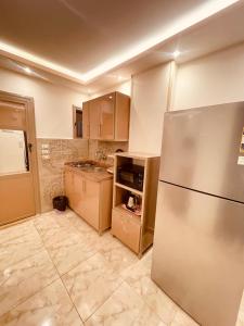 a kitchen with a stainless steel refrigerator in it at El mansour hotel apartmen 72 in Mansoura