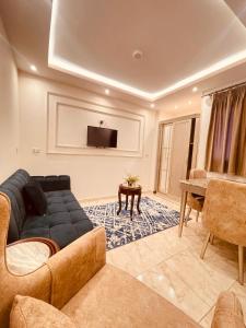 a living room with a couch and a tv at El mansour hotel apartmen 72 in Mansoura