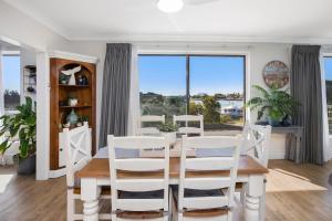 a dining room with a table and chairs and a window at BJ Mick's Lakefront Apartment in Forster