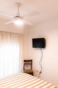 een slaapkamer met een bed en een flatscreen-tv bij COSTANERA APART in Villa María