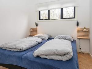 two twin beds in a room with two windows at Holiday home Ebeltoft CLXXXIX in Ebeltoft