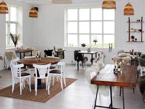 a dining room with tables and chairs and windows at Holiday home Gilleleje XV in Gilleleje
